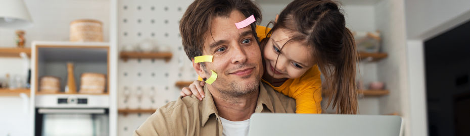 Mann Post-it im Gesicht und Kind schauen in einen Laptop