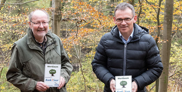 2 Männer im Wald mit Wertplakette in den Händen