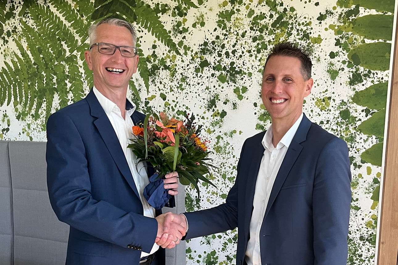 Vorstand Thomas Taubenberger gratuliert der Bereichsleiterin Silvia Leger zur Prokura mit Blumenstrauß