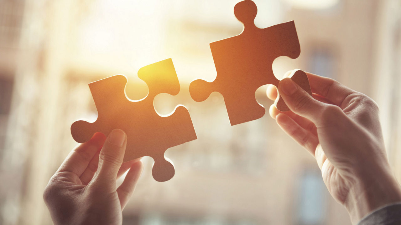 Puzzelteile, die in die Sonne gehalten werden. 