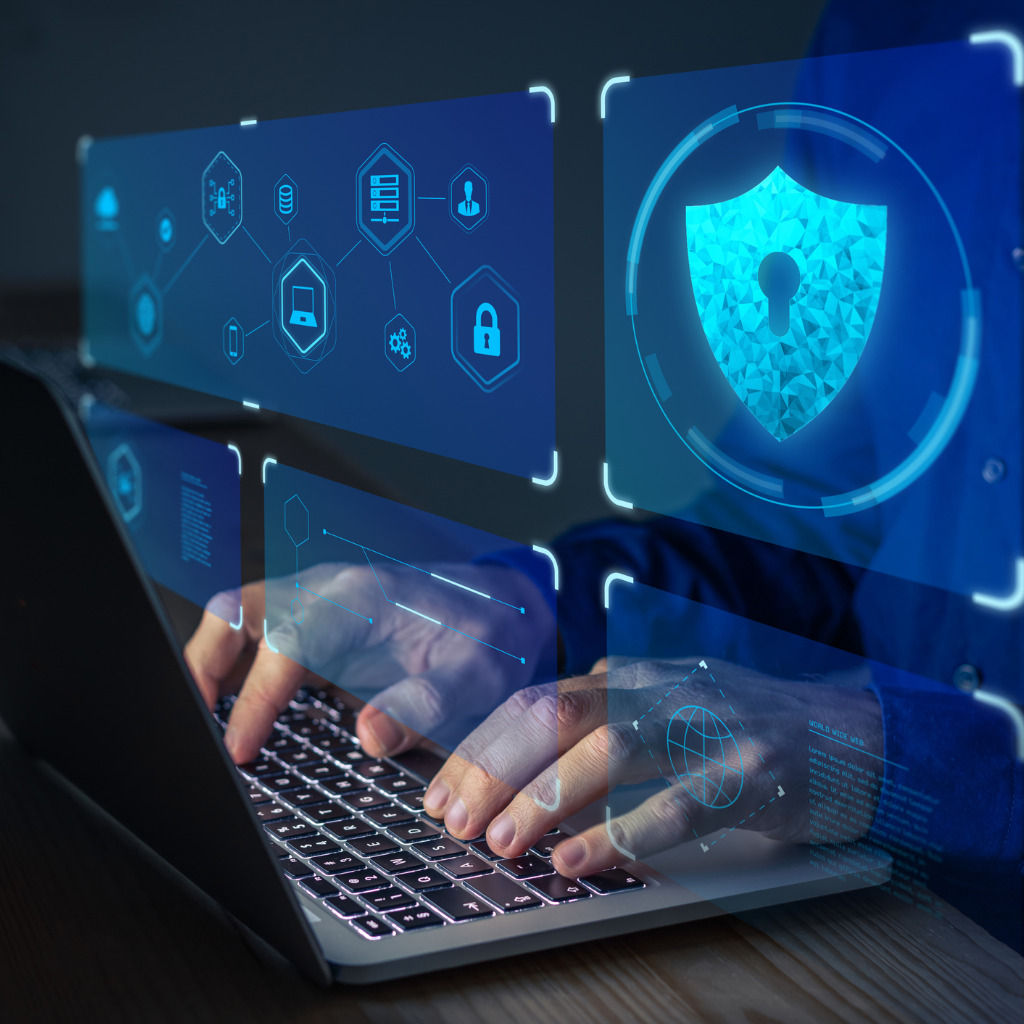 Hände tippen auf einem Laptop, umgeben von digitalen Symbolen zu Datensicherheit und Netzwerkschutz.