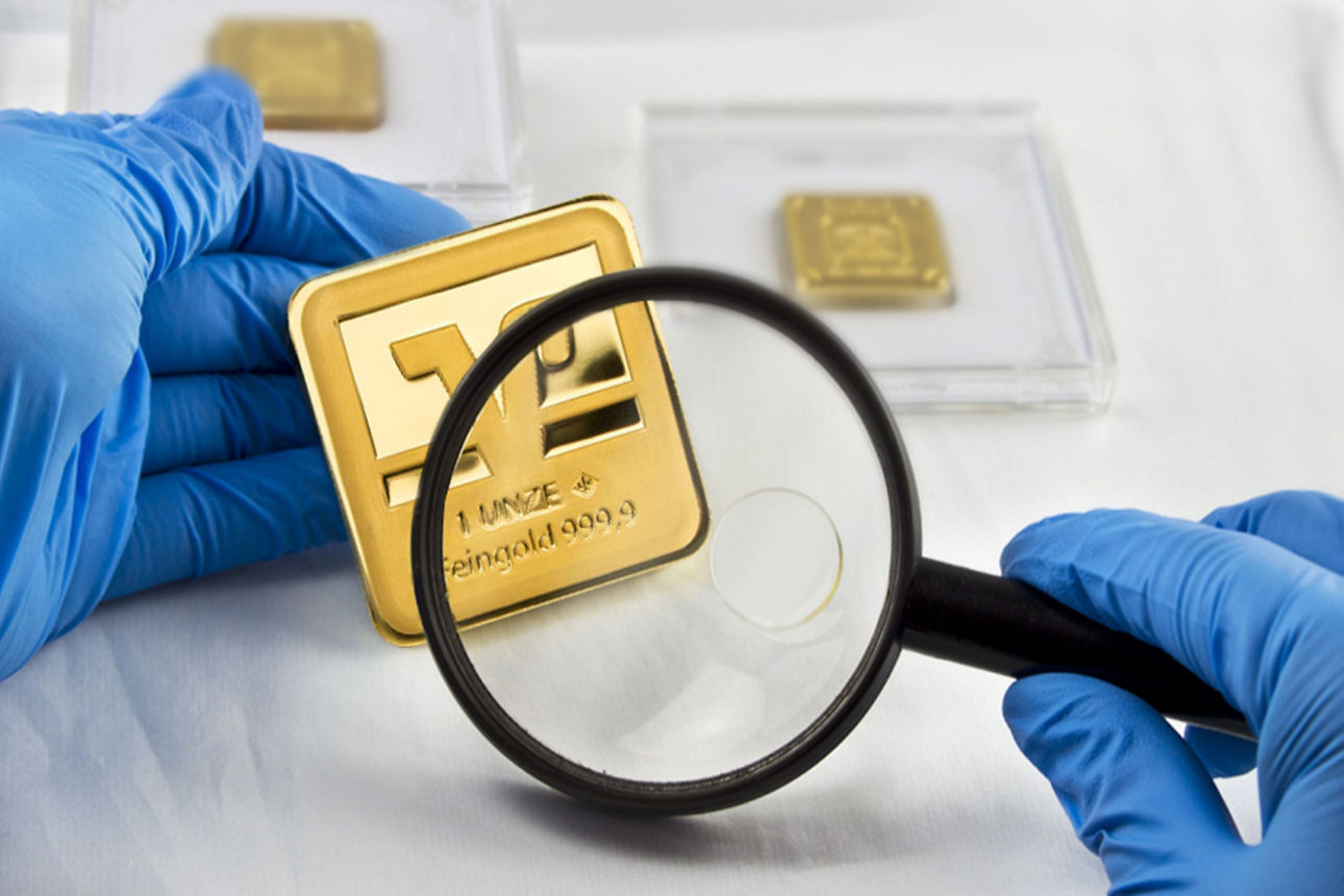 Lupe, die einen Goldbarren prüft und vergrößert