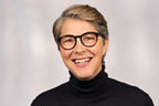 Sandra Quenter hat kurze hellbraune Haare und trägt eine schwarze runde Brille und einen schwarzen Rollkragenpullover