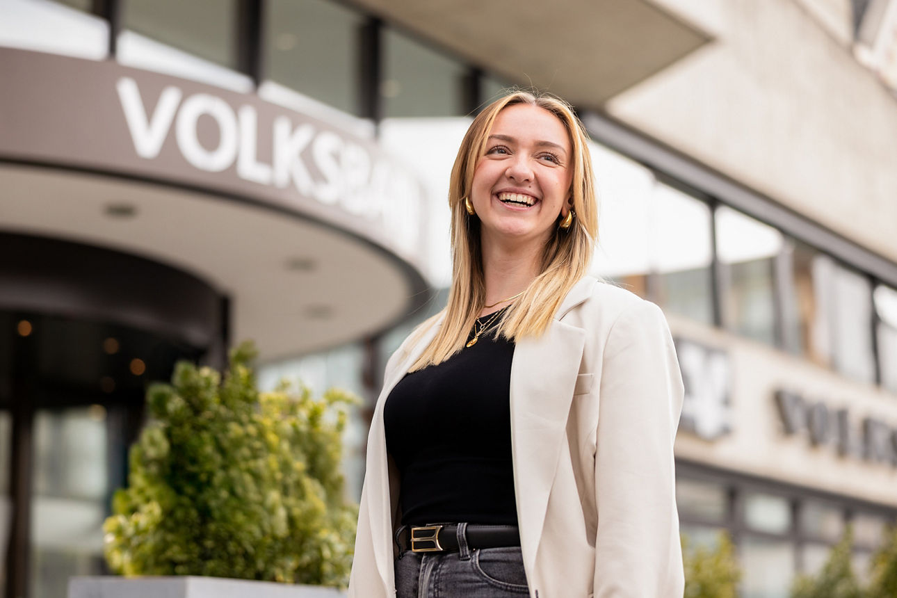 Lächelnde Frau vor einem Bankgebäude