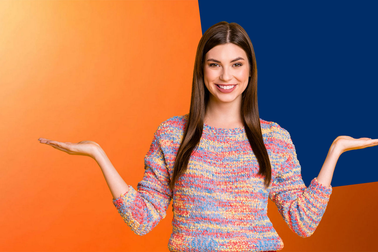 Junge Frau im bunten Pullover vor orange-blauer Wand