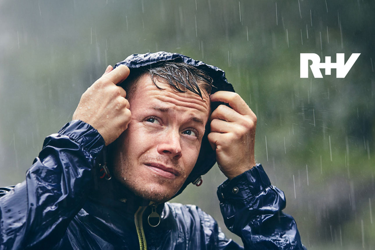 Vater und Sohn stehen lachend vor einem Haus