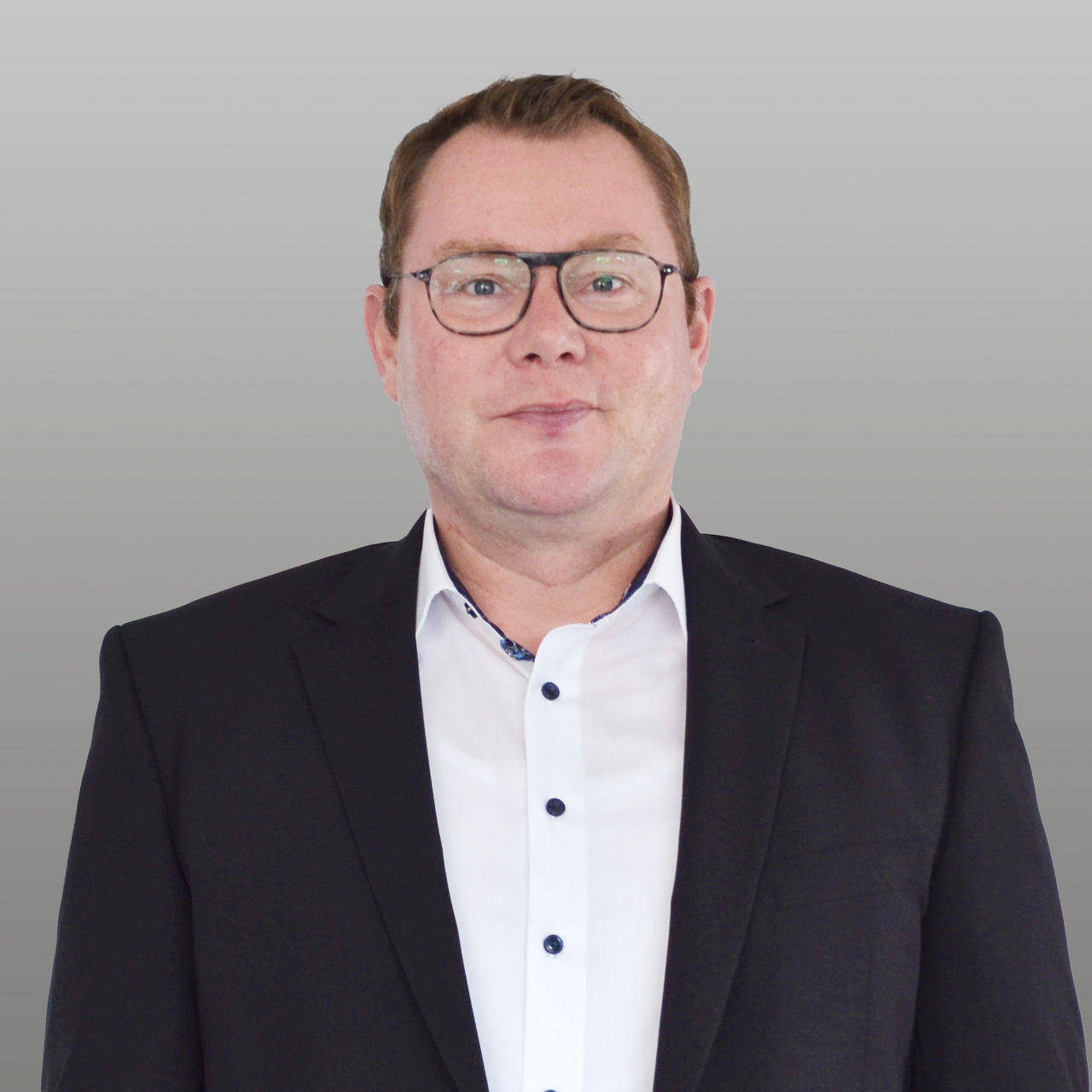 Geschäftskundenberater Stefan Röhrig vor grauem Hintergrund