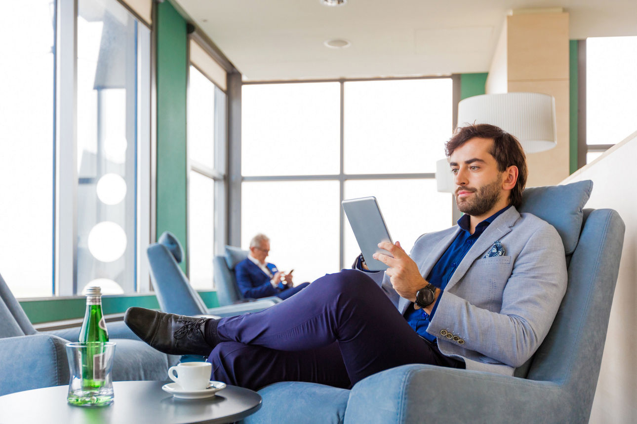 Ein Mann in einem Sessel liest auf einem Reader