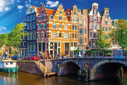Blick auf Amsterdam und die schmalen Giebelhäuser mit den verzierten Fassaden und einer Brücke über den Amsterdamer  Kanal