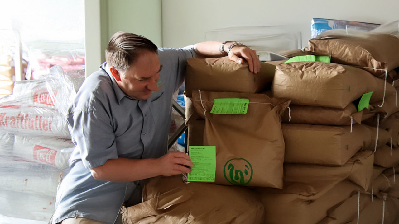 Ein Mitarbeiter vor einer Palette mit Getreidesäcken