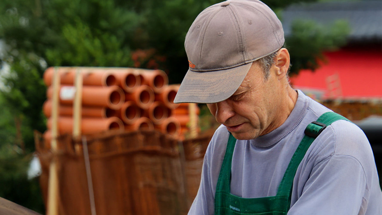 Ein Handwerker vor einer Palette KG-Rohre