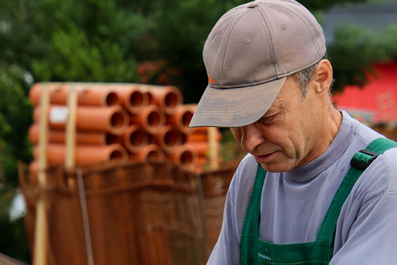 Ein Handwerker vor einer Palette KG-Rohre
