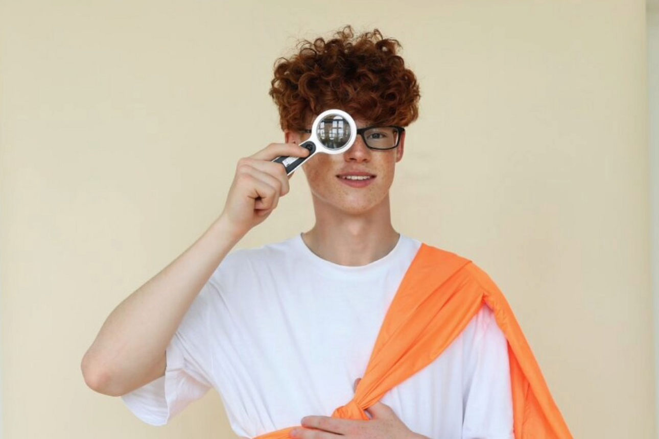 Schüler schaut durch Lupe