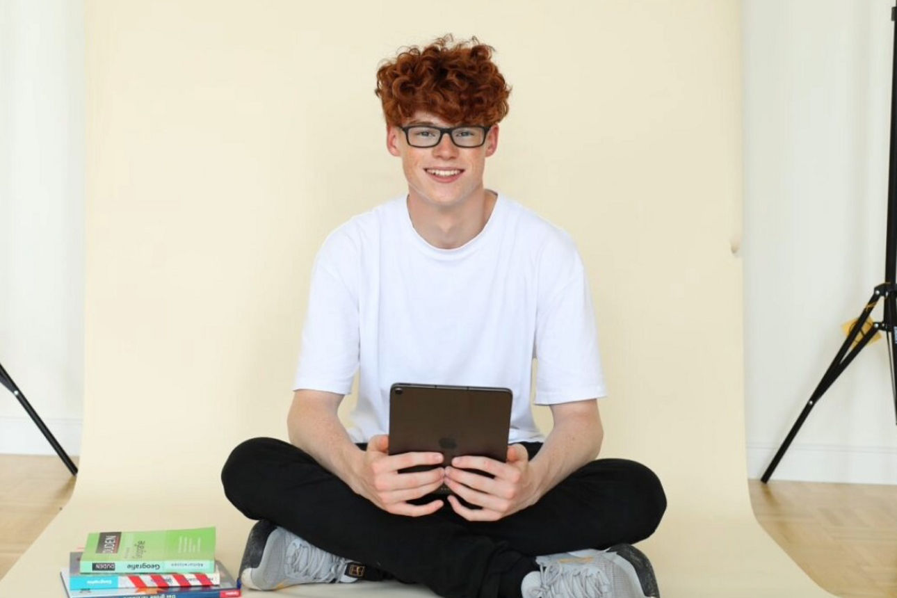 Schüler sitzt im Schneidersitz 