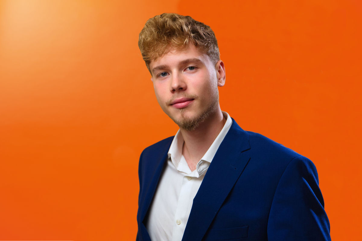Junger Mann beim Videodreh vor einer Leinwand