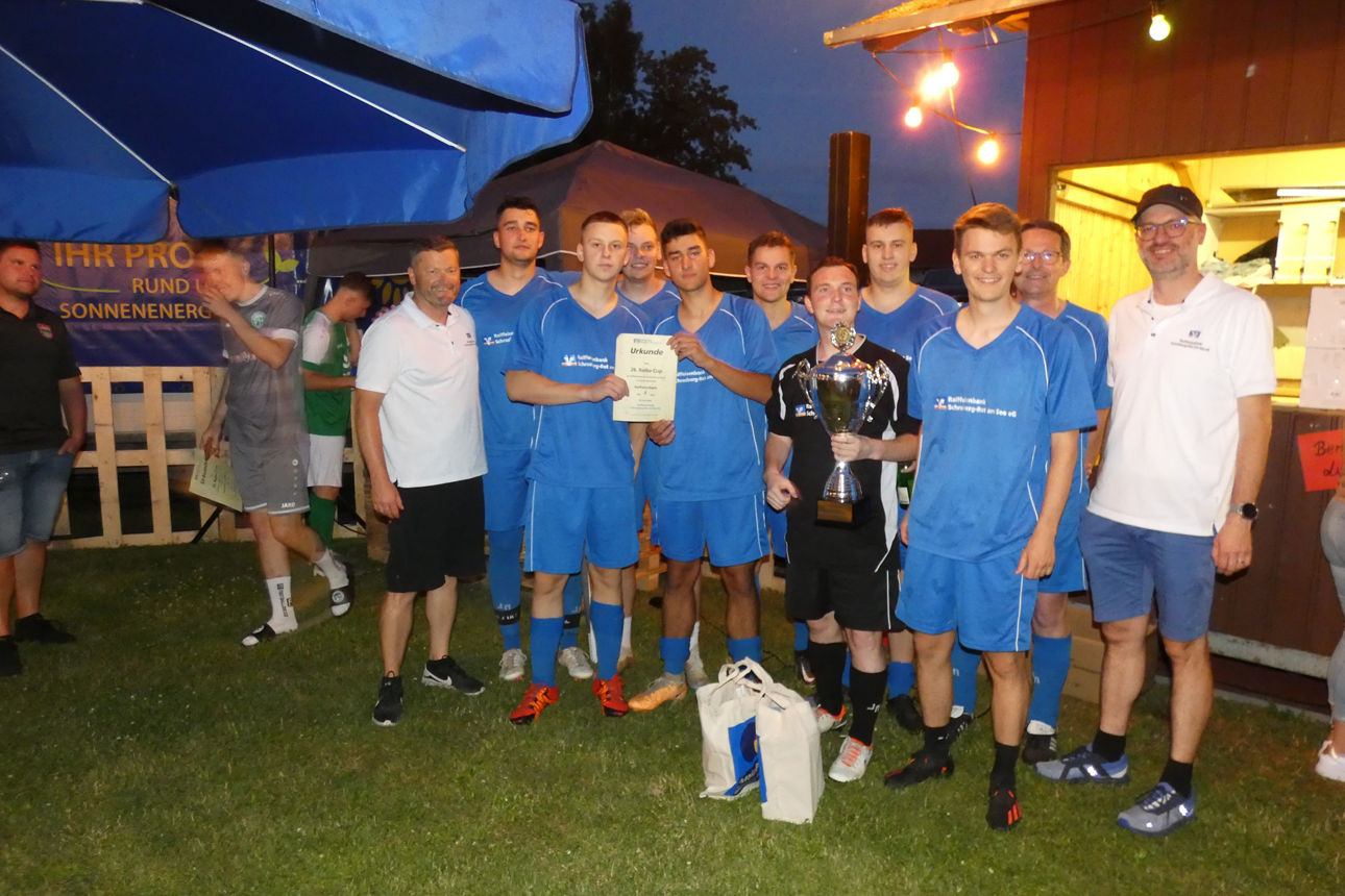 Gewinnerteam steht mit Urkunde und Pokal auf dem Rasen