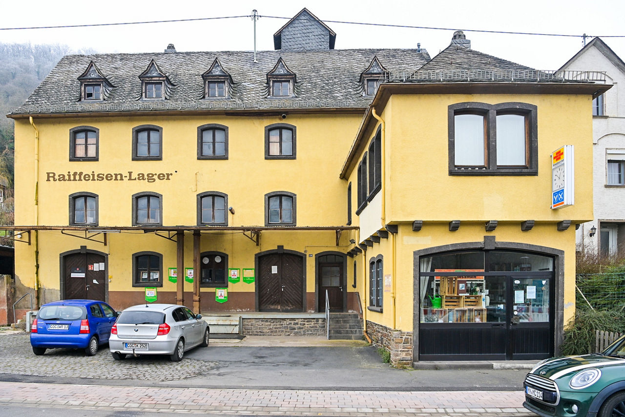 Ein mehrstöckiges Gebäude mit vielen Fenstern und gelber Fassade ist zu sehen.