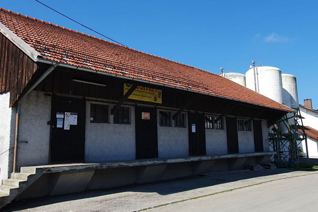 Niedriges Gebäude mit Giebeldach und weißen Wänden