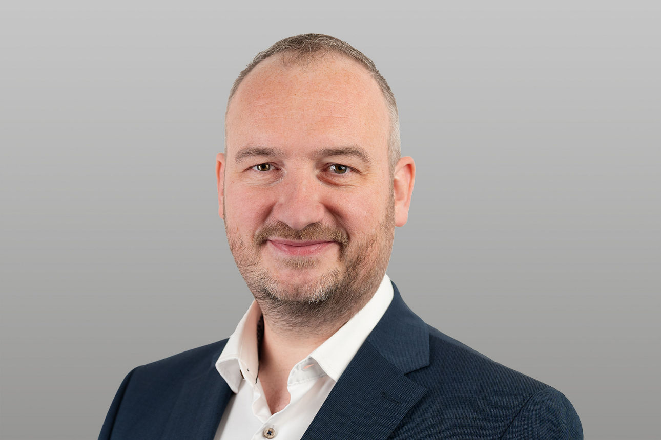 R+V Finanzberater Marc Rink  vor grauen Hintergrund