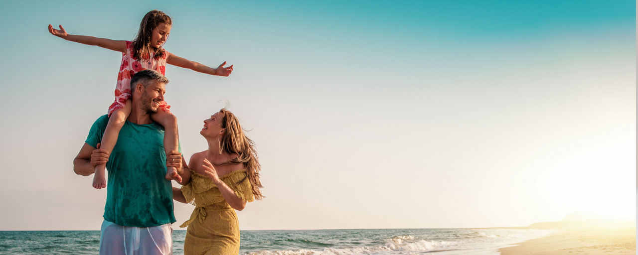 Mann, Frau und Tochter am Strand in der Sonne