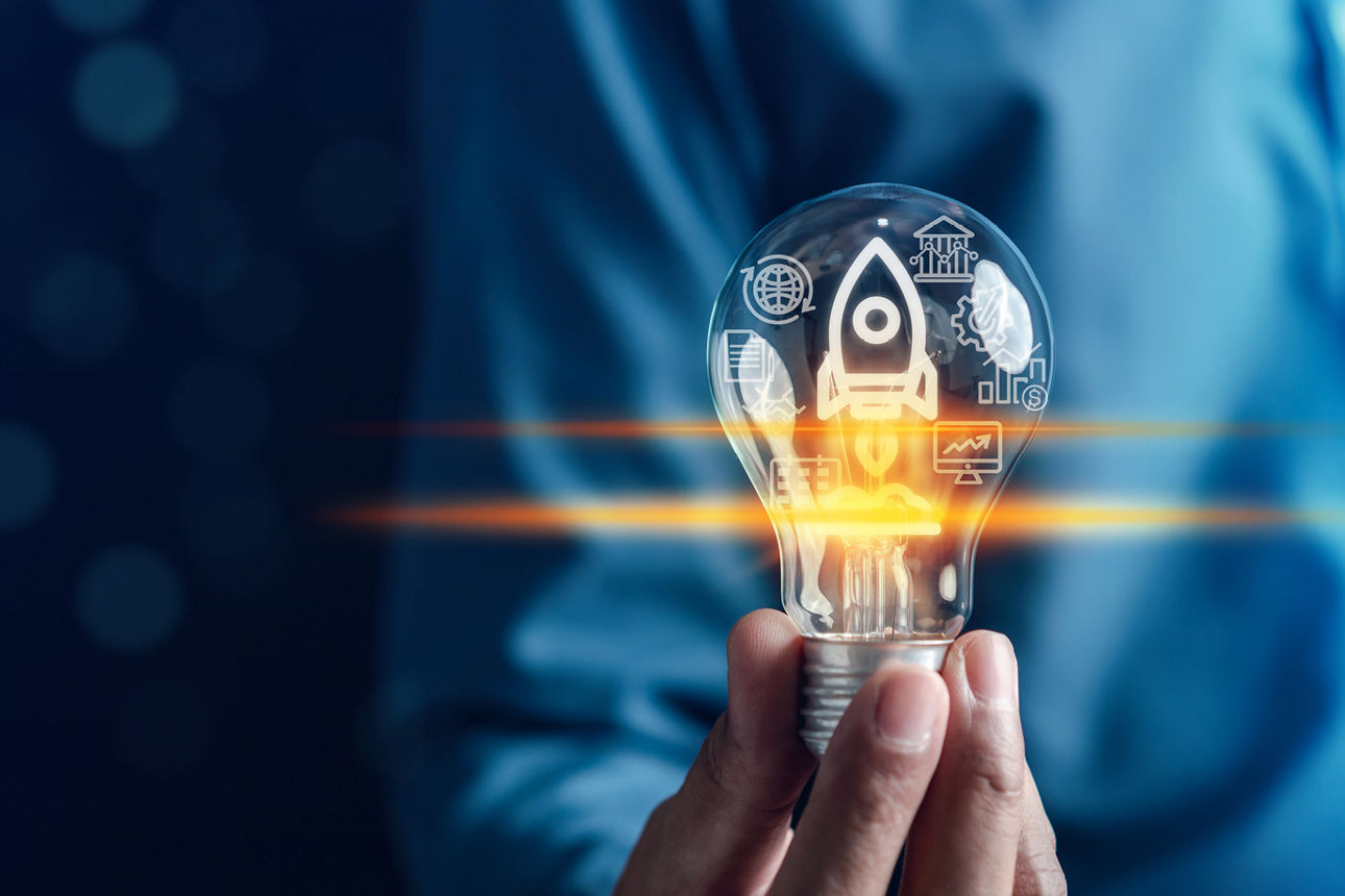 Hand hält beschriftete Glühbirne hoch 