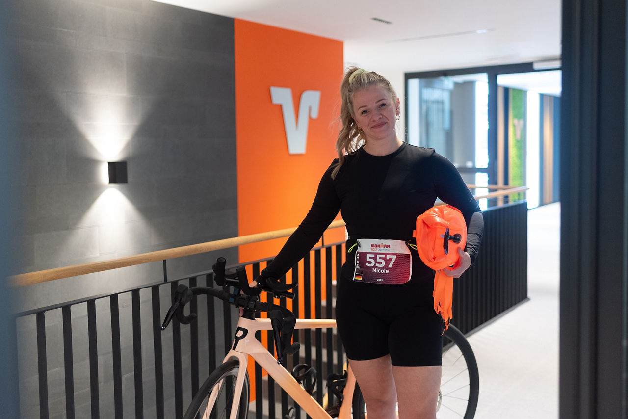 Nicole Schult mit ihrem Triathletenfahrrad und der Schwimmboje im Laufdress in der Bank