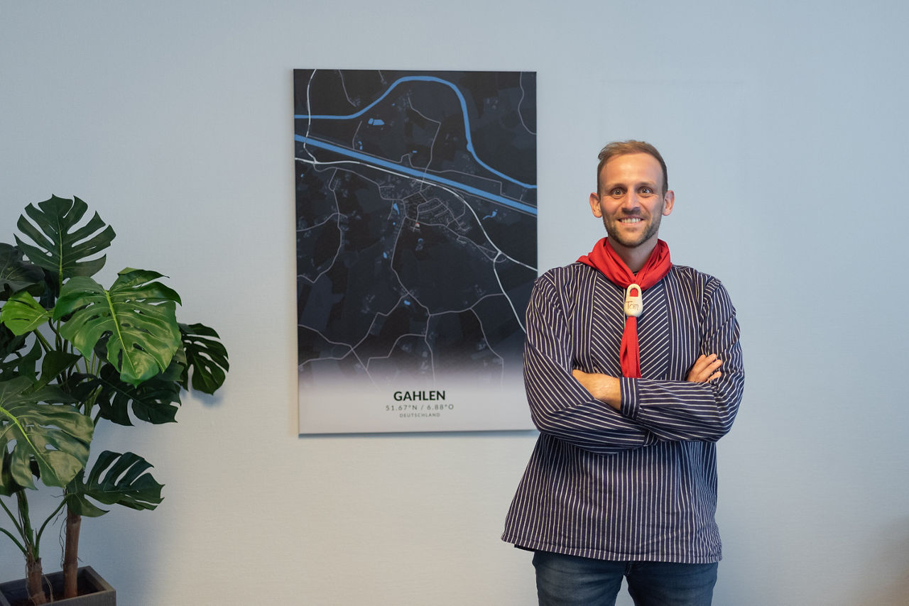 Tom Weber in der Kluft des Heimatvereins Gahlen in der Filiale in Gahlen vor einem Bild