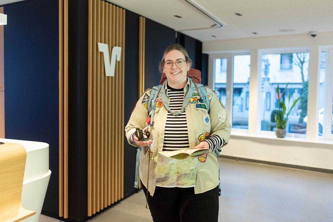 Sophia Schetter steht mit ihrer Pfadfinderkluft, einer Karte und einem Kompass in der Schalterhalle der Volksbank Schermbeck.
