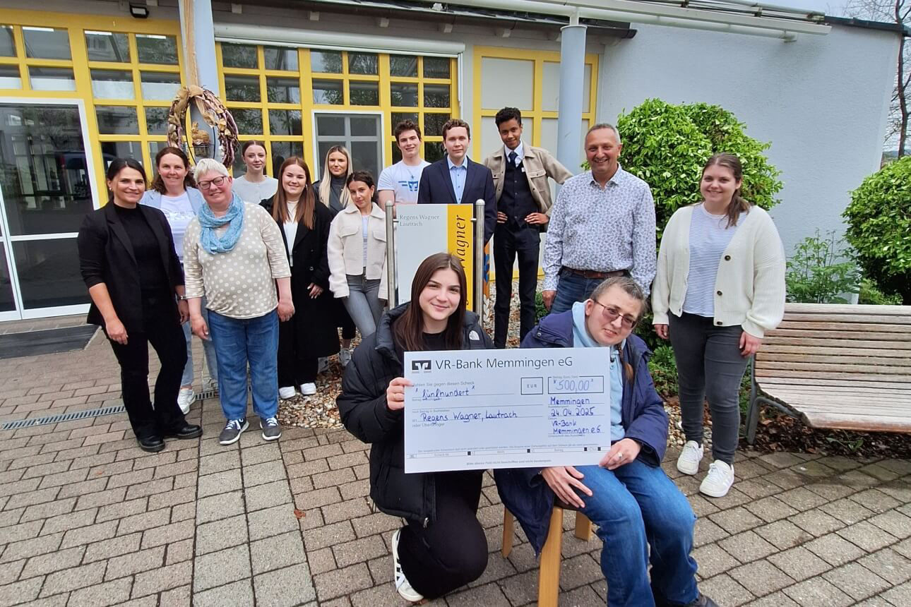 Gruppenbild der Azubis der VR-bank Memmingen und den Bewohnern von Regens Wagner bei der symbolischen Scheckübergabe