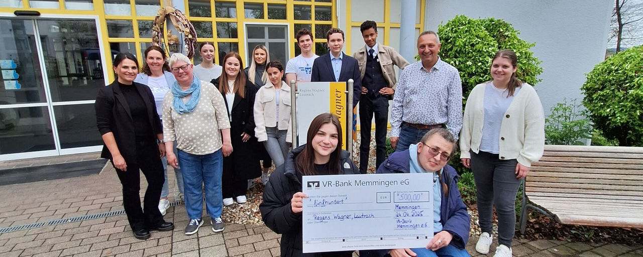 Gruppenbild der Azubis der VR-bank Memmingen und den Bewohnern von Regens Wagner bei der symbolischen Scheckübergabe