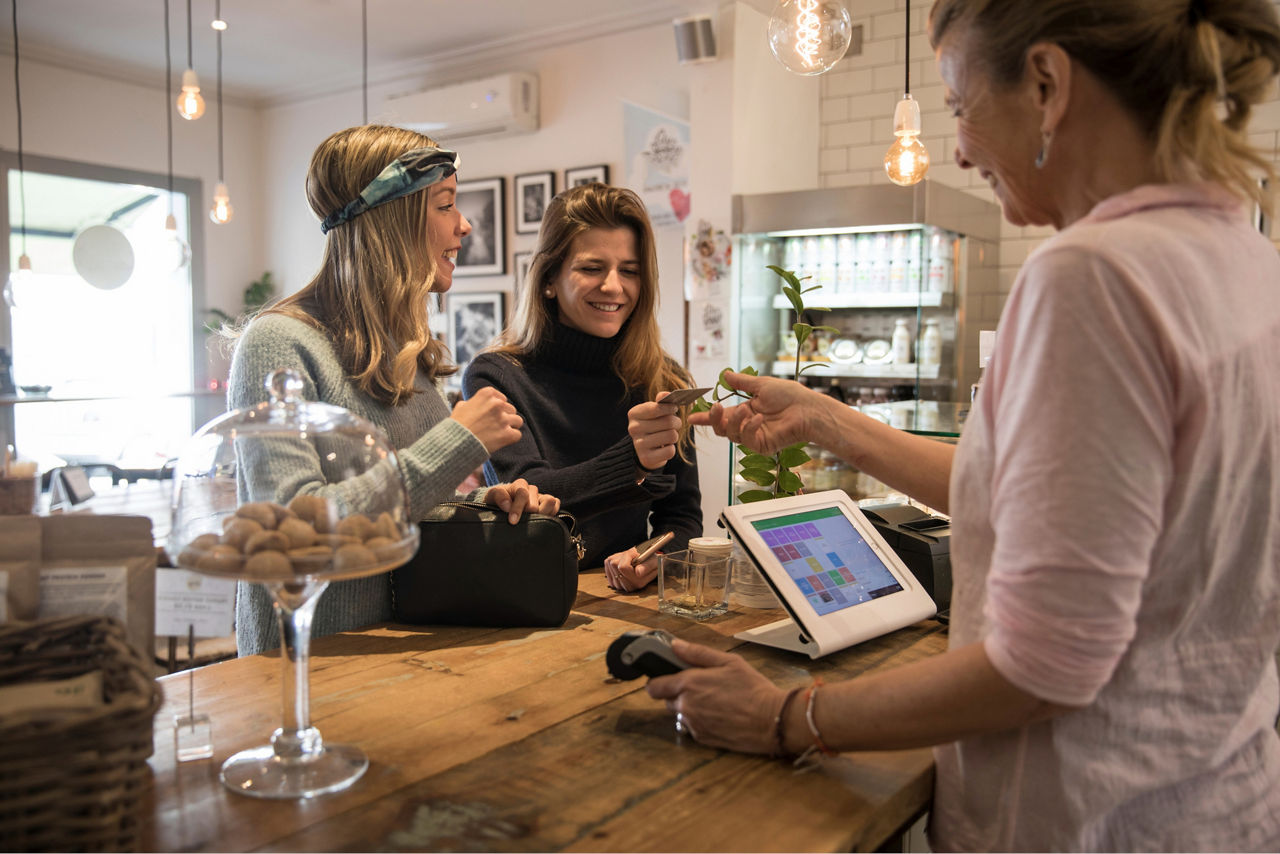 Zwei Frauen, die mit einer girocard an der Kasse bezahlen