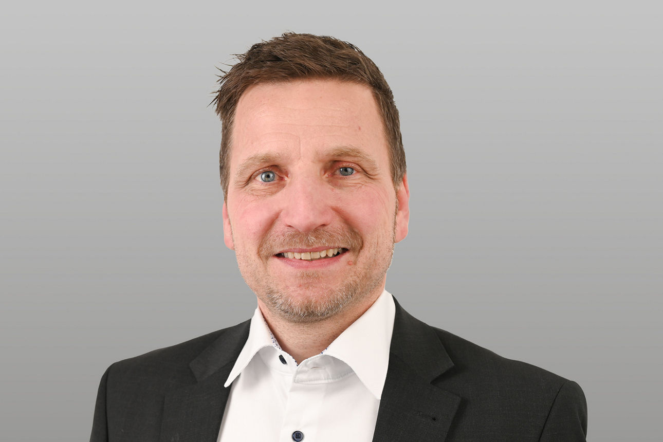 Privatkundenberater Adam Reicherl vor grauen Hintergrund