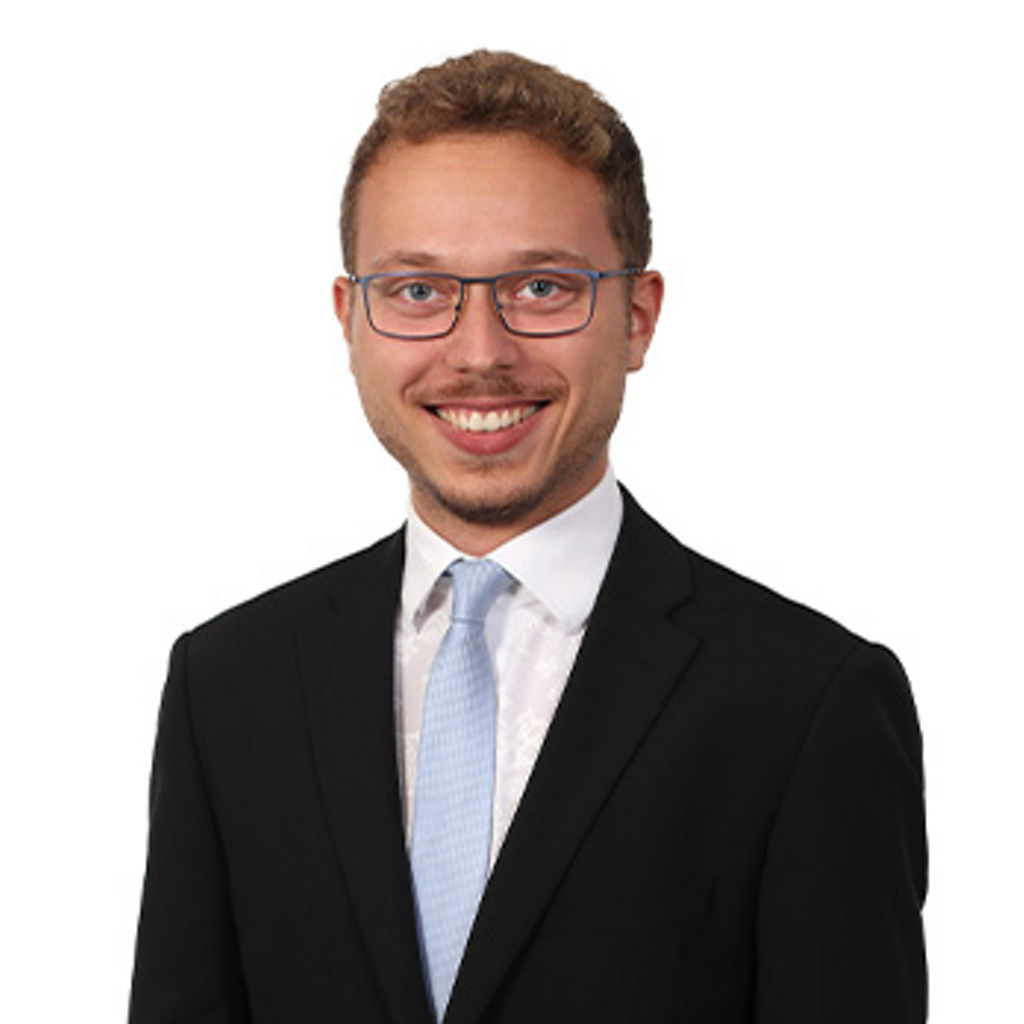 Freundlich lächelnder Mann im Anzug, unser Teamleiter KundenDialogCenter Niclas Reichmann
