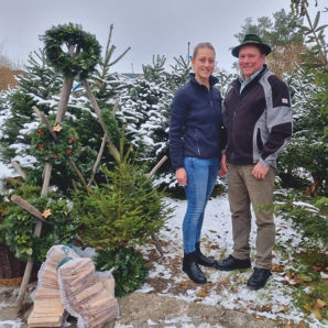 Herr und Frau Reimann stehen zwischen den Christbäumen