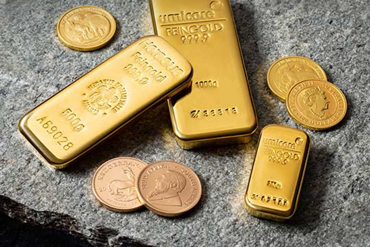 Edelmetalle Goldmünzen und Goldbarren liegen auf einer Steinplatte