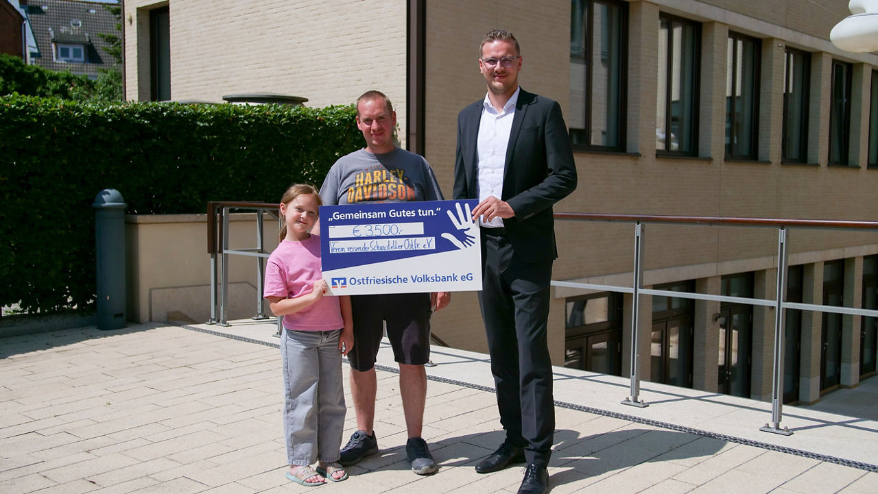 Ein Firmenkundenberater, der Kunde und ein Mädchen wärend sie ein Scheck entgegennehmen. 