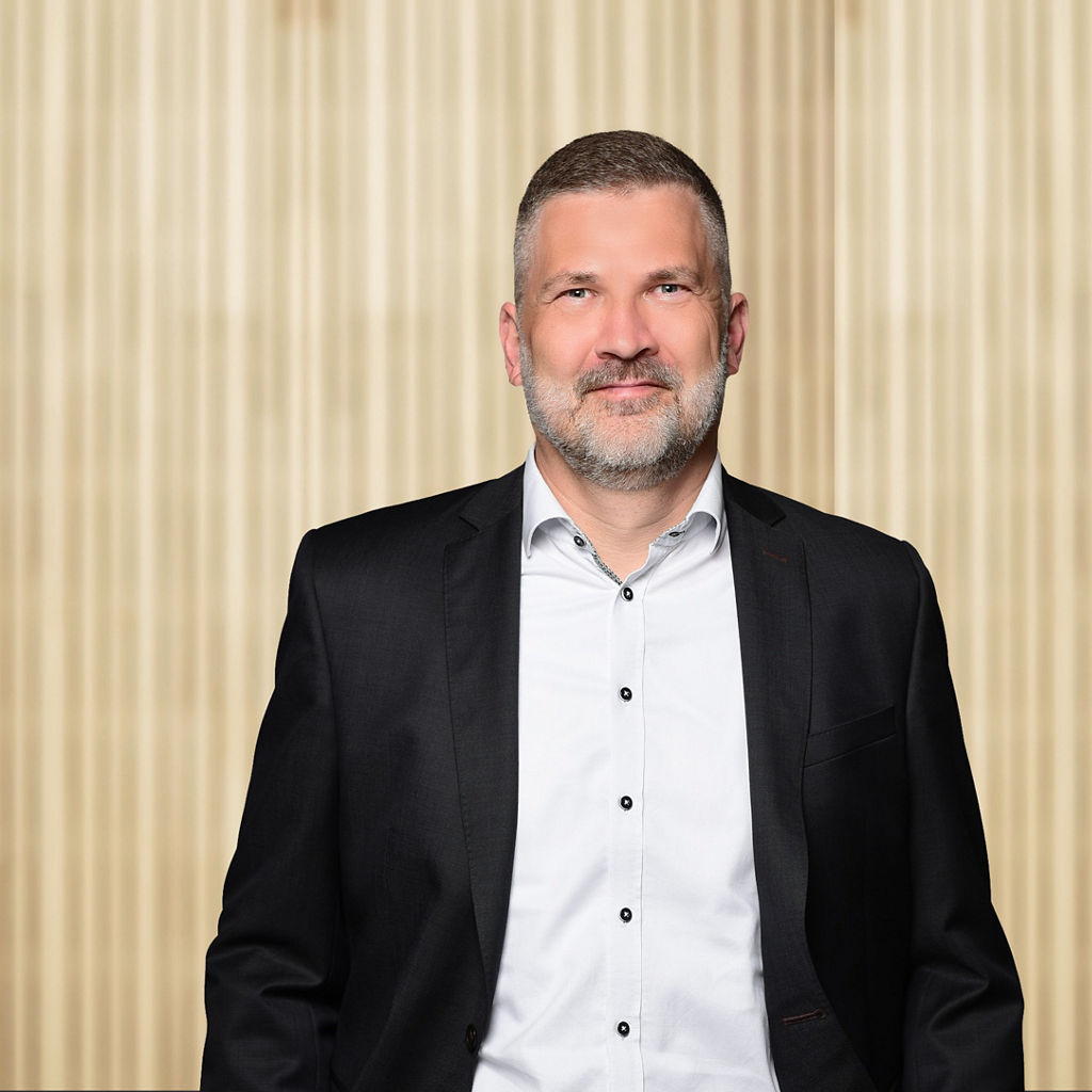 René Plathe vor einer Holzwand