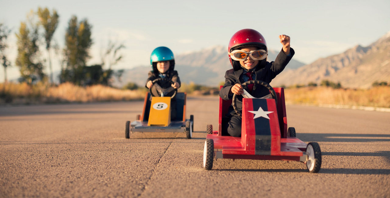 Zwei Kinder fahren in Kinder-Rennwagen