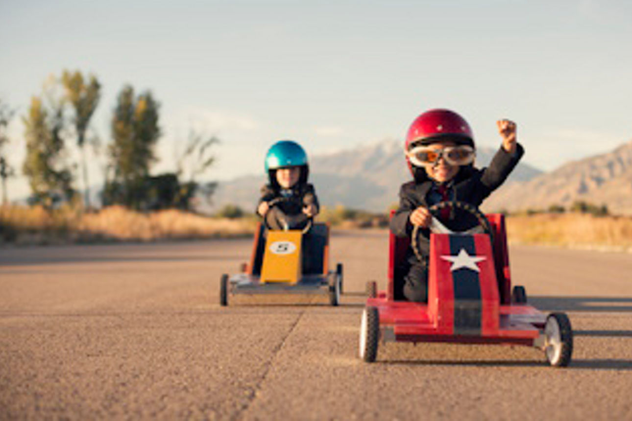 Zwei Kinder fahren in Kinder-Rennwagen