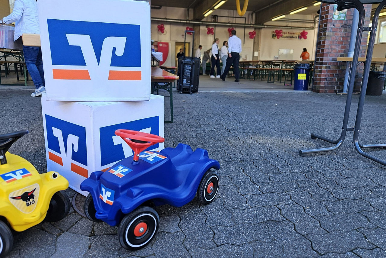 Volksbank Bobbycars stehen auf dem Boden vor Volksbank Hockern