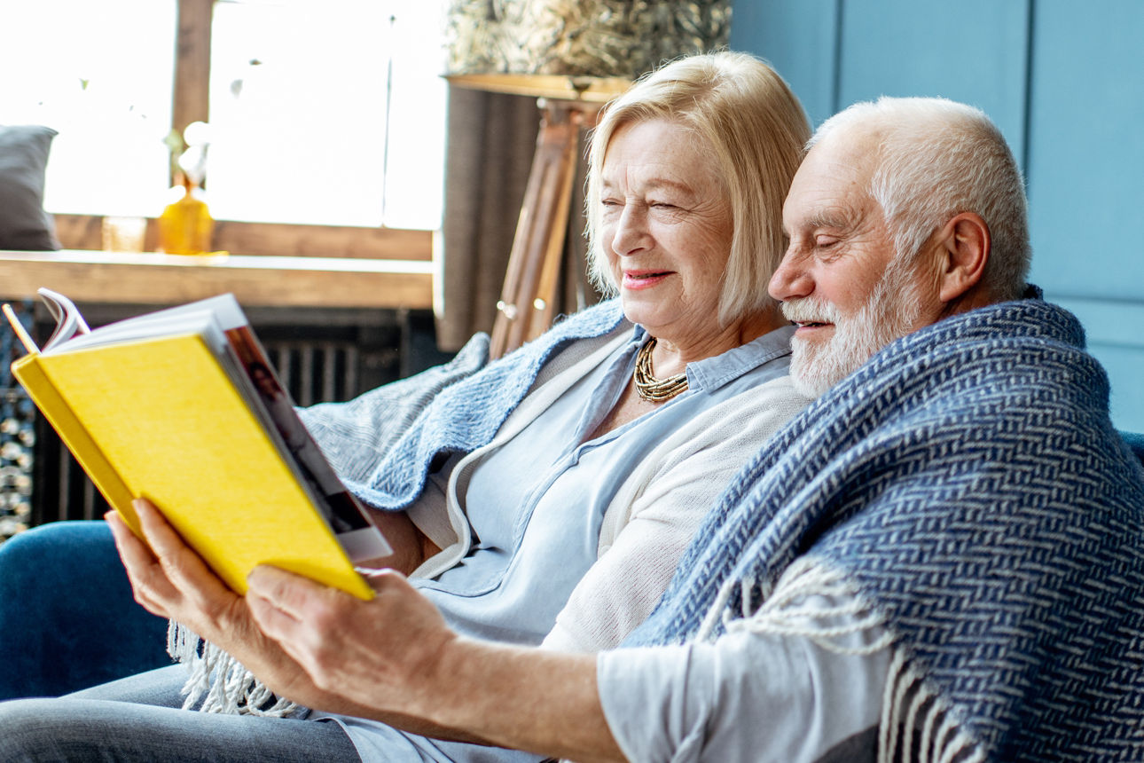 Altes Ehepaar liest in einem gelben Ordner
