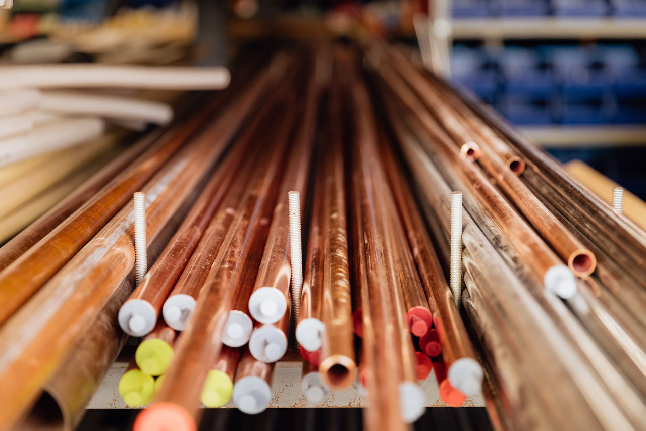 agerregal im Sanitär‑ und Heizungsbetrieb von „Ress GmbH“ mit verschiedenen Kupferrohren sowie Installationsmaterialien, die für Sanitär‑ und Heizungsarbeiten vorbereitet, sortiert und geordnet gelagert sind