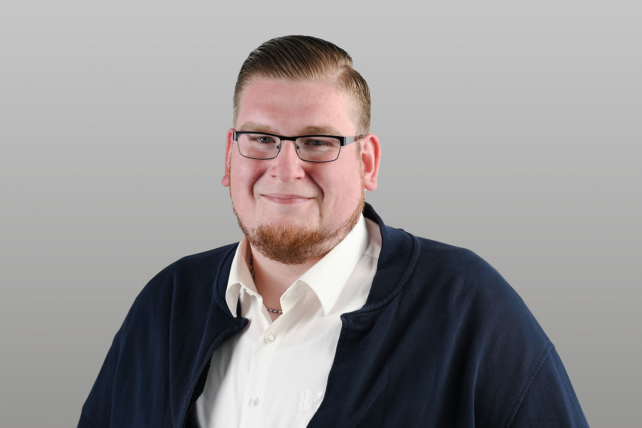 KundenServiceCenter Kevin Reuber vor grauen Hintergrund