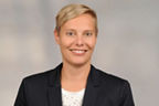 Mitarbeiterin Saskia Reusch hat kurze blonde Haare und trägt ein Businessoutfit
