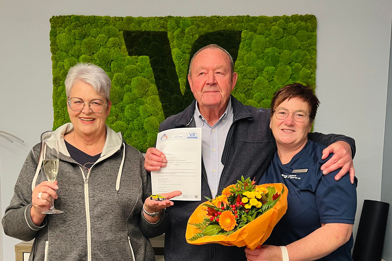  Personen stehen vor einer Wand