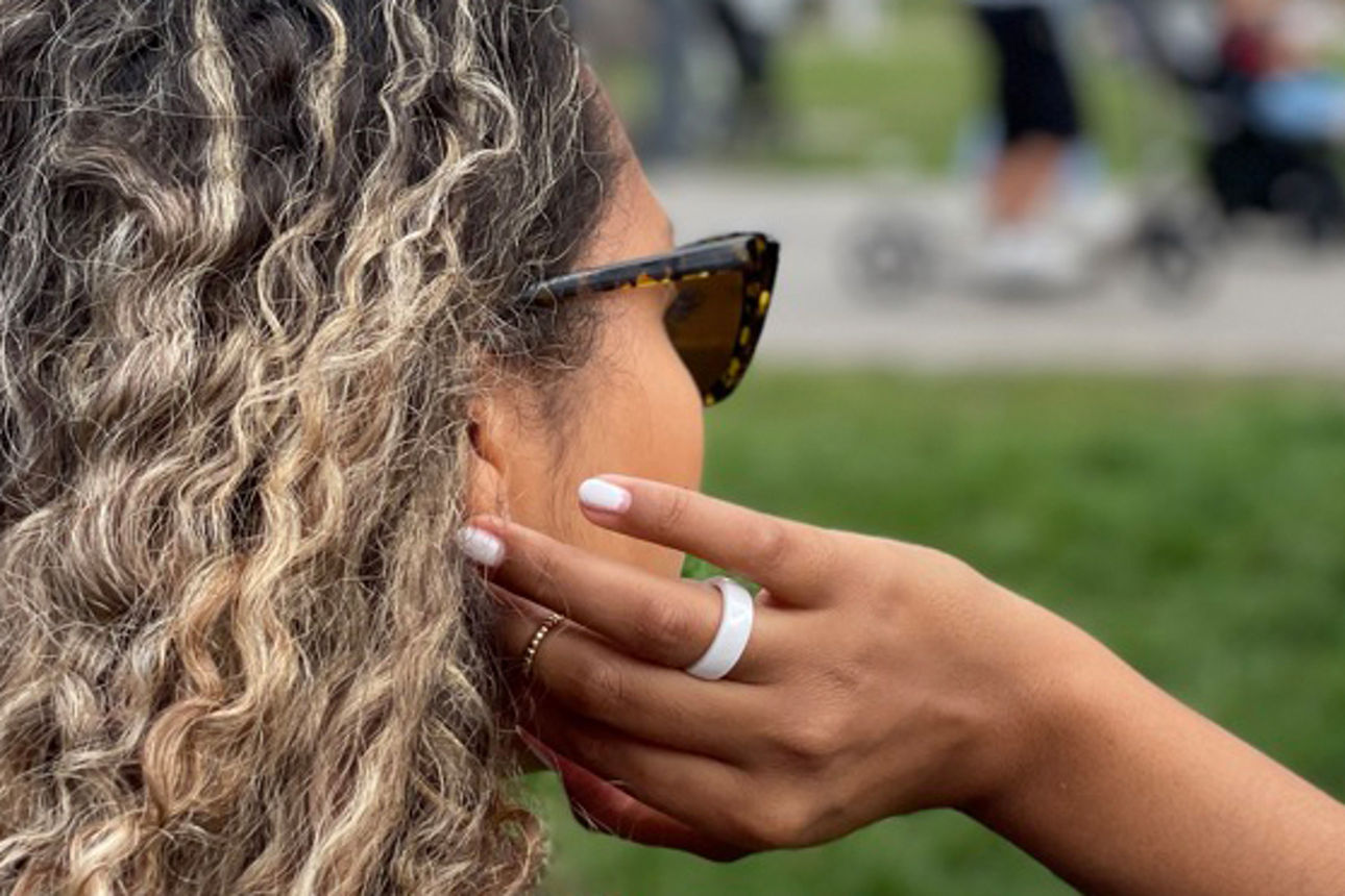 Frau mit Locken und Sonnenbrille von der Seite