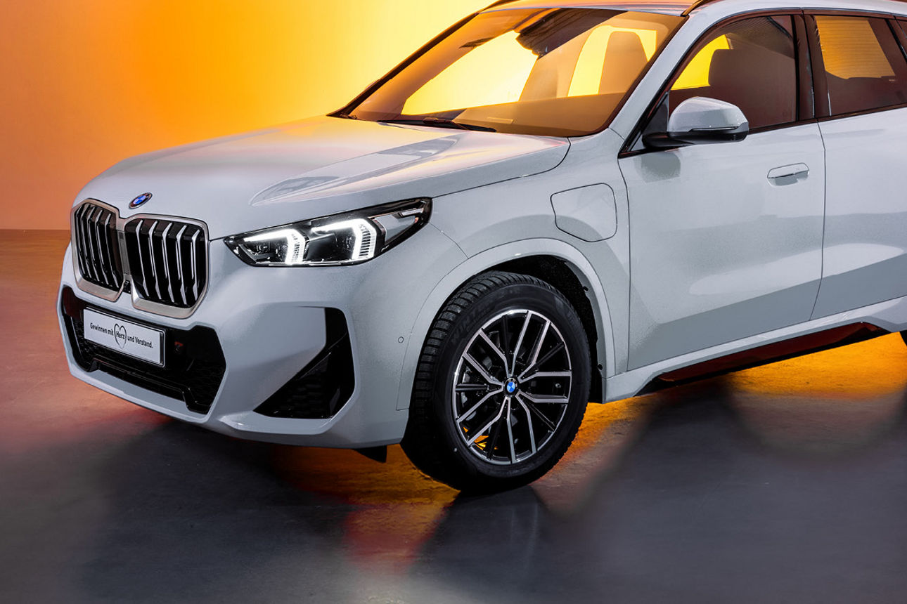 Weißer BMW mit orangenem Hintergrund.