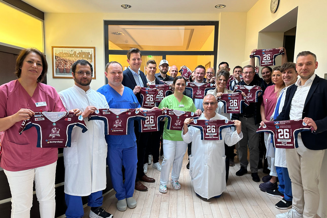 Viele Klinikmitarbeiter halten die Trikots in die Kamera.