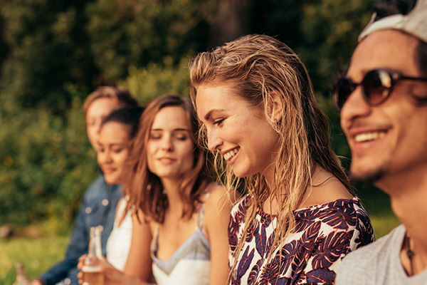 Freunde sitzen zusammen am Abend am See