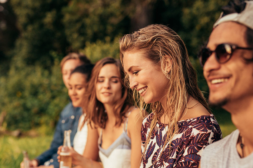 Freunde sitzen am Abend zusammen am See